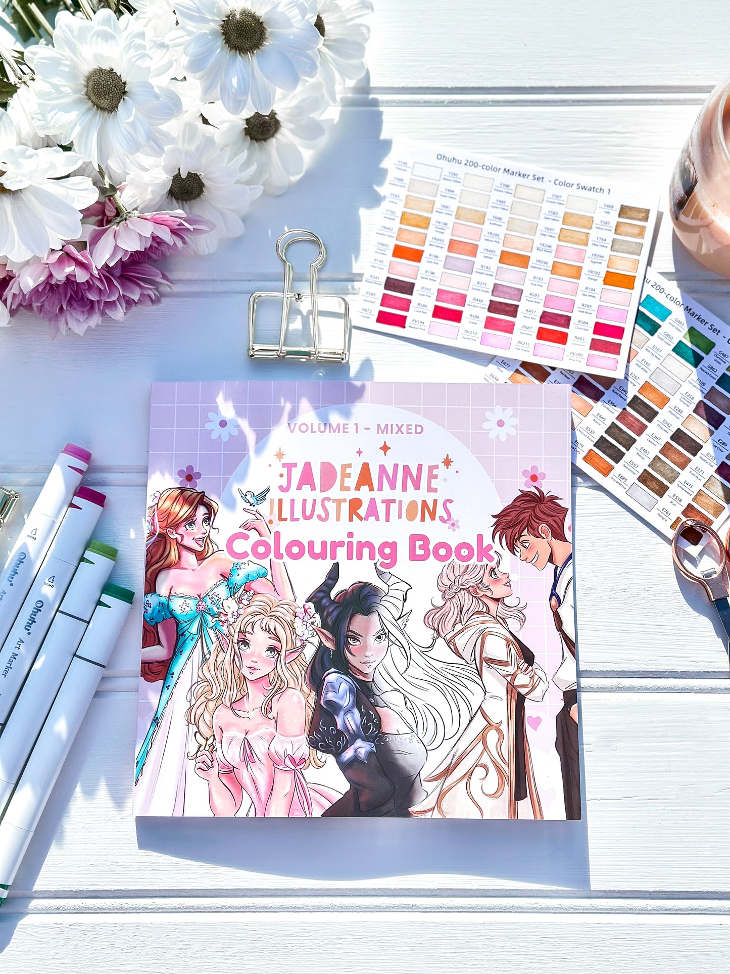 Jadeanne Illustrations colouring book with markers and color swatches on a light surface.