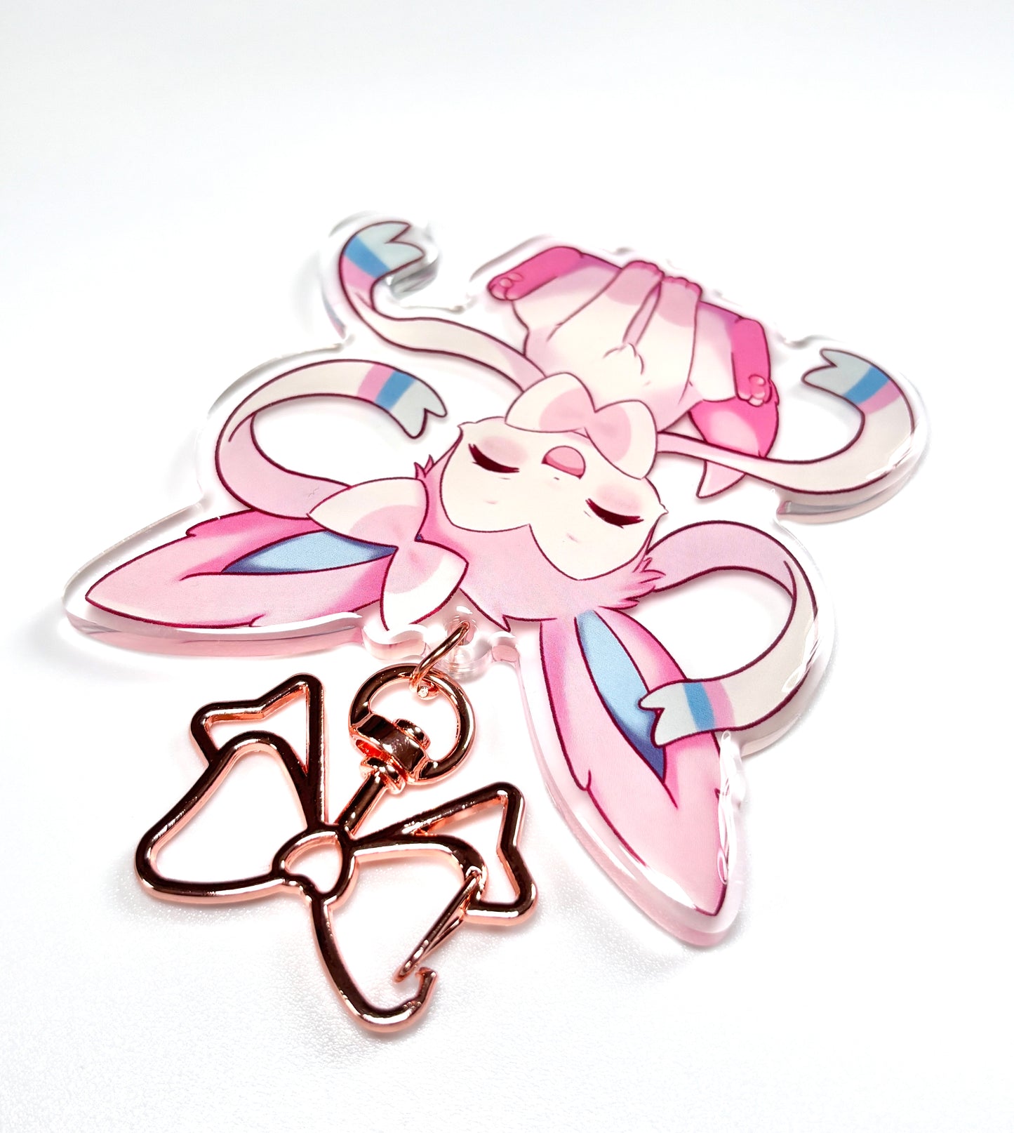Kawaii sylveon acrylic keychain with metal rose gold clip. cute keychain of sylveon from pokemon. pink aesthetic bag accessory. mainly focusing on the metal hardware of acrylic keychain