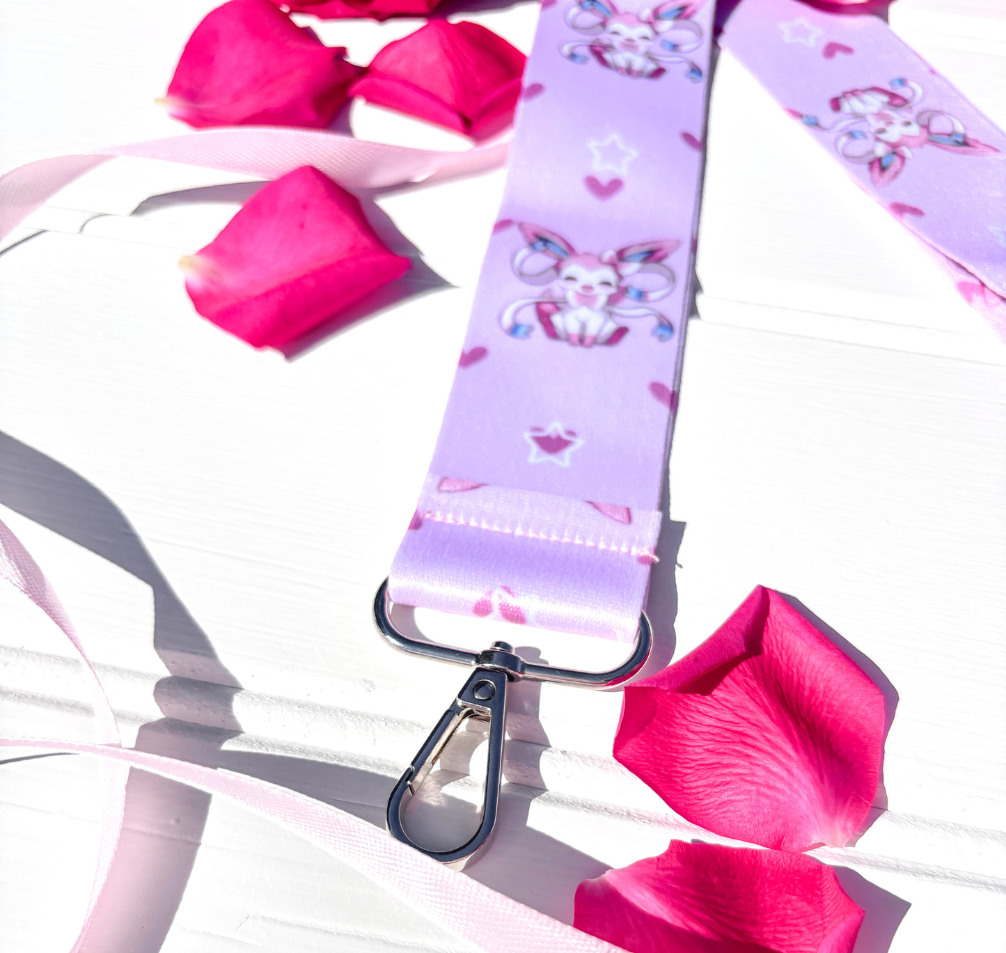 Lanyard with pokemon kawaii character design on a white surface with pink petals