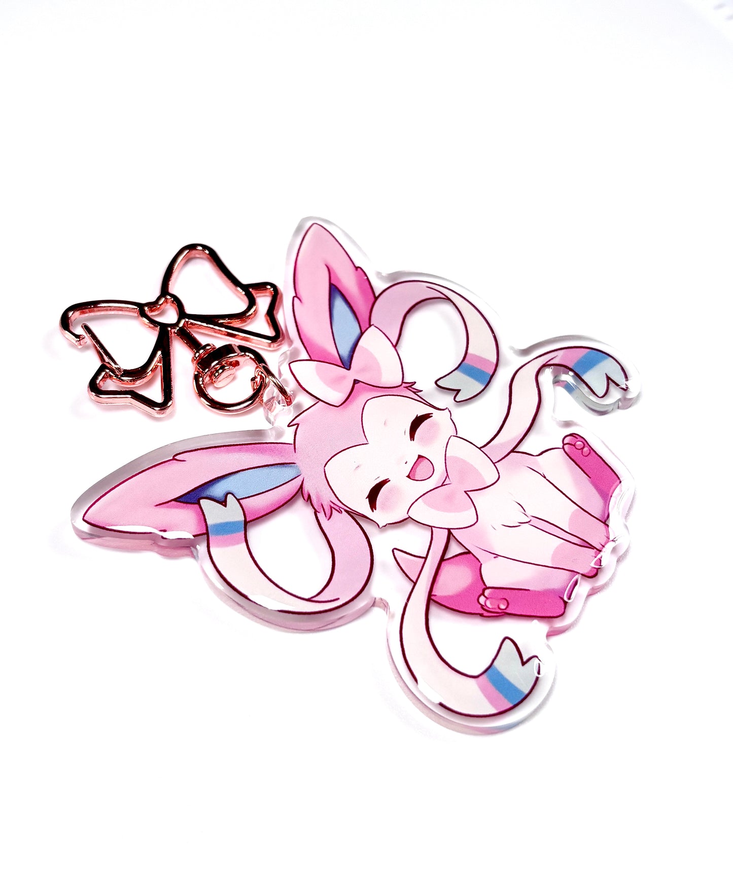 Kawaii sylveon acrylic keychain with metal rose gold clip. cute keychain of sylveon from pokemon. pink aesthetic bag accessory. focusing on the side view to see the resin doming of keychain.