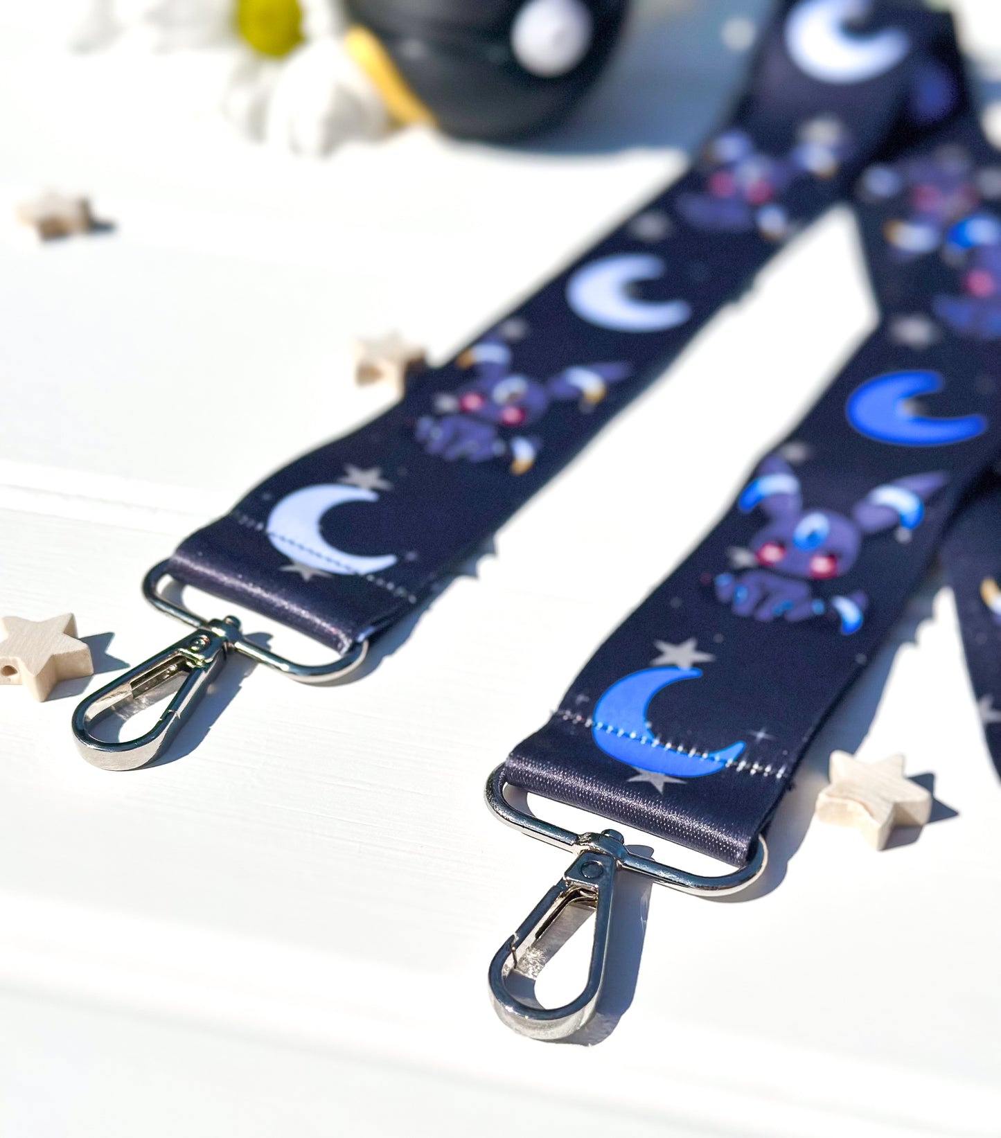 black strap with moon and star pattern on with the pokemon umbreon on with a white background