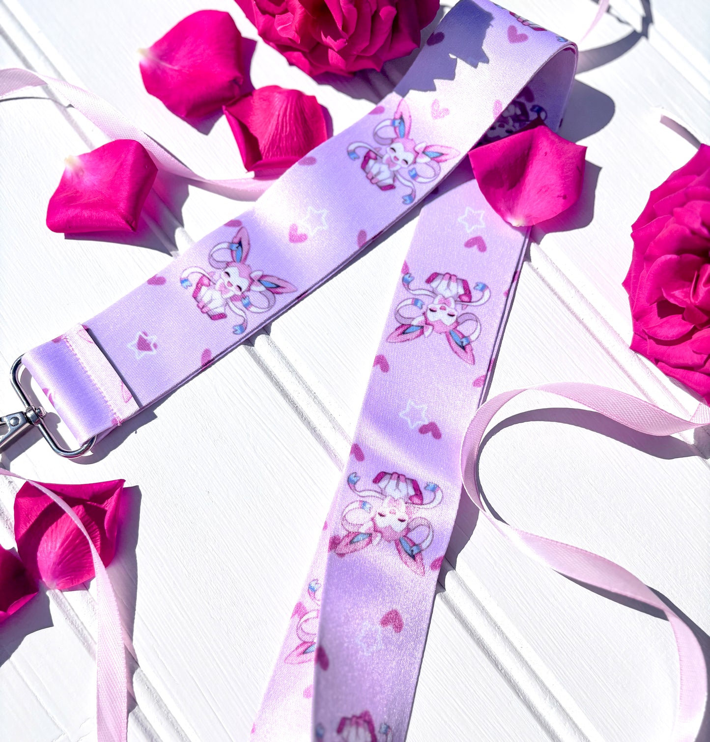 Lanyard with kawaii Sylveon character design on a white surface with pink roses