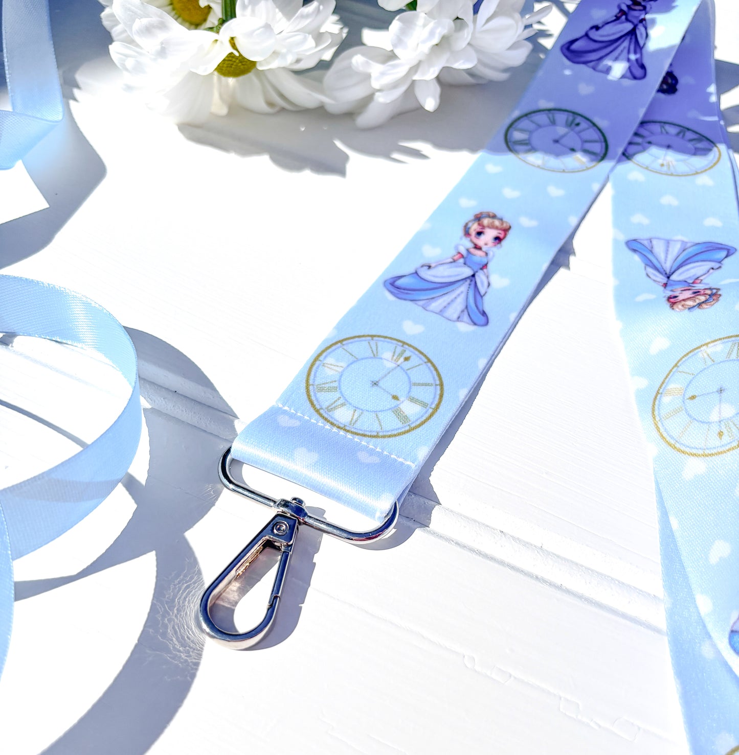 Lanyard with cinderella character design and clock pattern on a light blue background