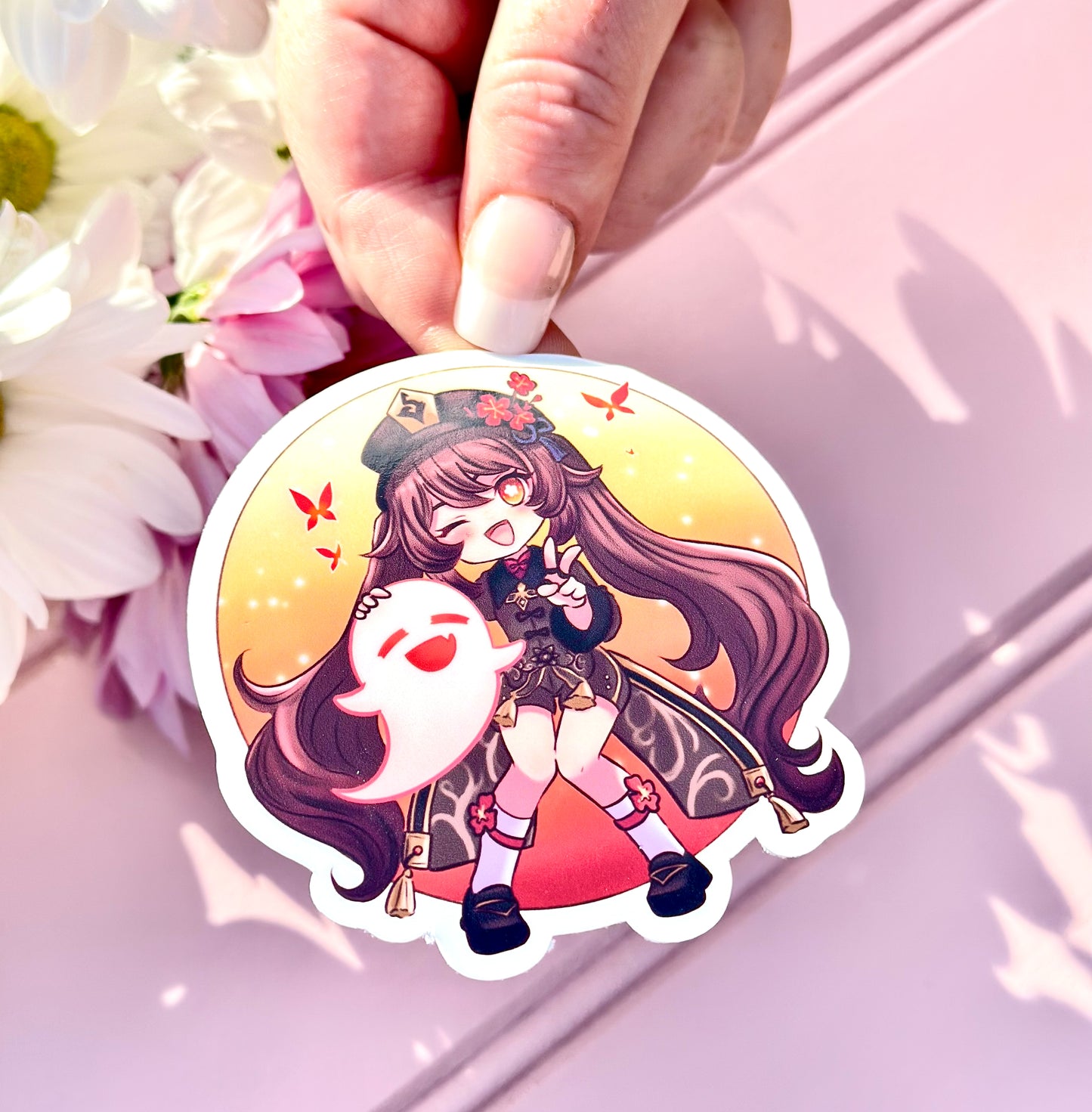 Sticker of Hu tao character held by a hand with flowers in the background