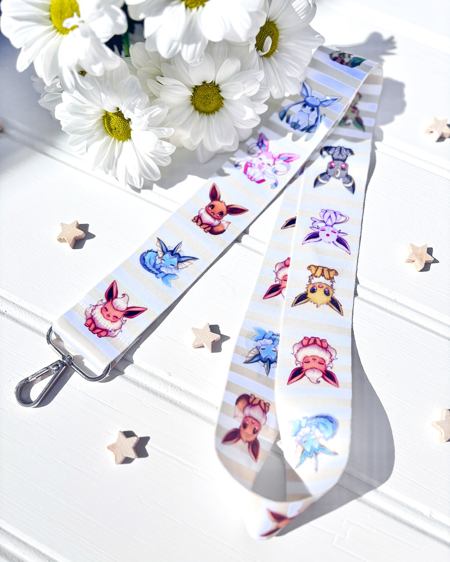 Lanyard with pokemon character design on a white surface with flowers in the background