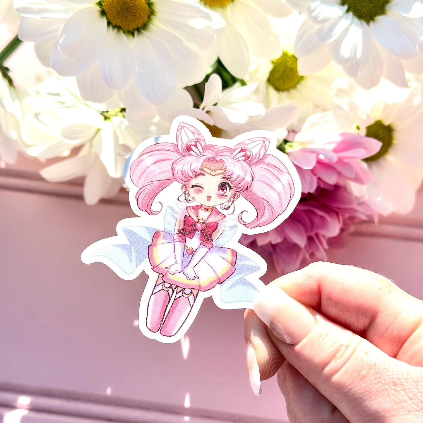 Sticker of a chibi usa from sailor moon character with pink hair and outfit held in front of flowers