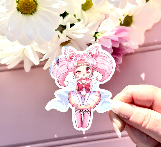 Sticker of a Chibi Usa character with pink hair held by a hand against a floral background