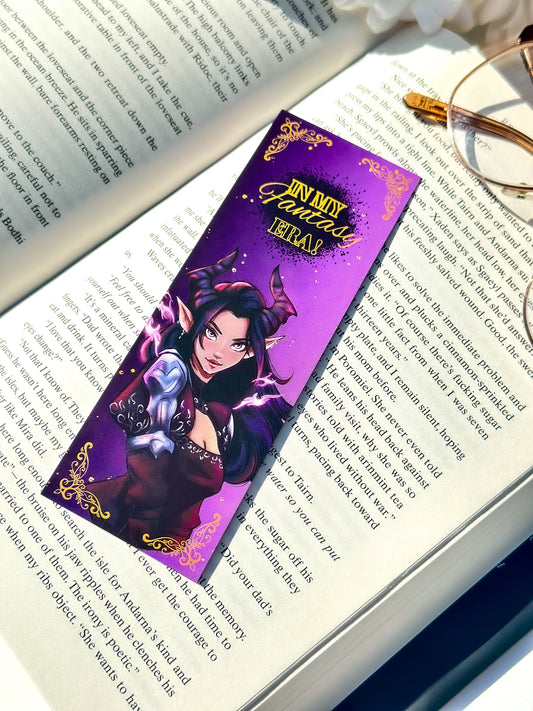 Fantasy-themed dark fae bookmark on an open book with glasses nearby