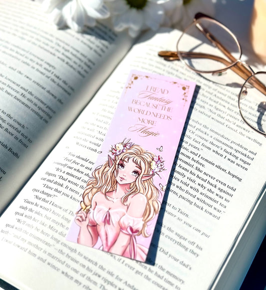 Book with a pink bookmark featuring an illustration of a elf princess with a flower crown, placed on an open book.