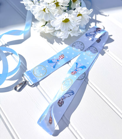 Blue lanyard with kawaii cinderella design on a white surface with flowers